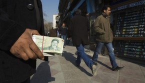 File photo of a money changer holding Iranian rial banknotes as he waits for customers in Tehran's business district